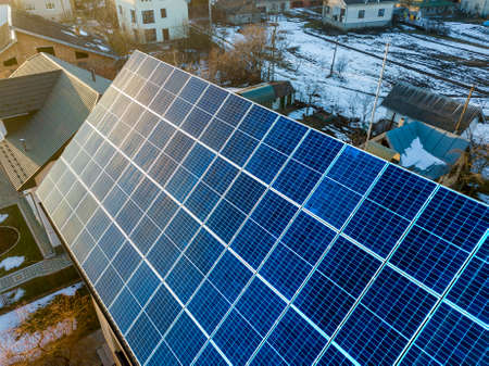 Close-up surface of lit by sun blue shiny solar  voltaic panels system on building roof. Renewable...