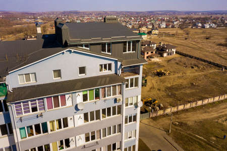 Aerial view of attic annex room exterior with plastic windows, roof and walls covered with brown...