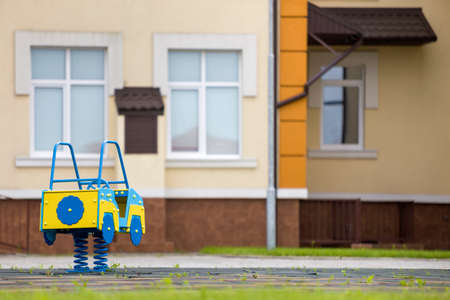 Kindergarten playground with bright toy car on spring. Children activities and recreation outdoors.