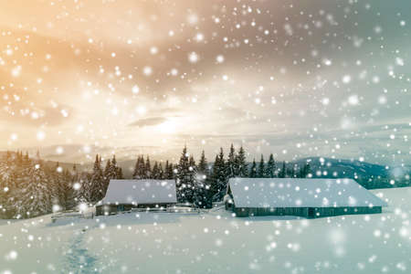 Winter mountain landscape. Old wooden houses on snowy clearing on background of mountain ridge,...