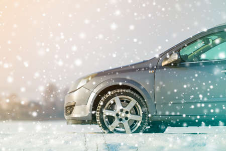 Close-up of car wheels rubber tires in deep winter snow. Transportation and safety concept.の写真素材