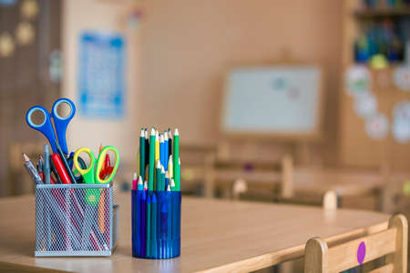 Stack of notebooks, colorful drawing pencils and stationery arrangement on copy space background.の写真素材