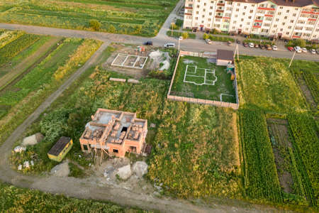 Aerial view of building site for future house, brick basement floor and stacks of brick for...