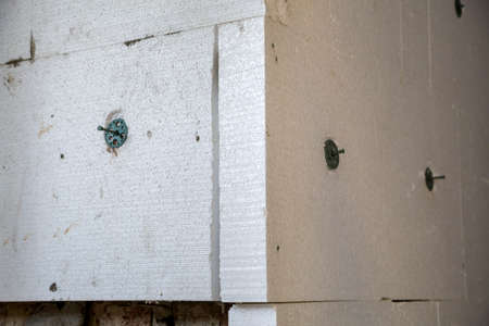 Insulation work of house walls with white foam sheets.