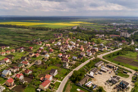 Aerial landscape of small town or village with rows of residential homes and green trees.の写真素材