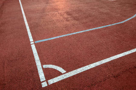 Close-up of white marking lines of outdoor basketball court.