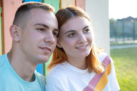 Happy young couple together outdoors. Redhead girl and boy having fun with each other.