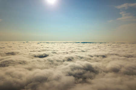 Aerial view over white clouds and clear blue sky.