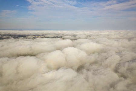 Aerial view over white clouds and clear blue sky.の写真素材