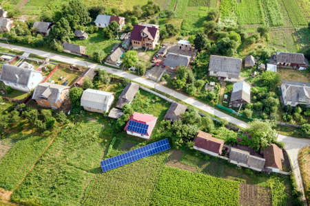 Aerial view of a house with blue solar panels for clean energy.