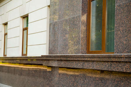 Close up view of part of a building facade with the surface of granite wall. Natural stone materials.の写真素材