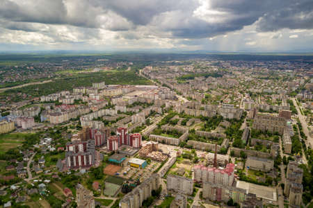 Aerial view of town or city with rows of buildings and curvy streets in summer. Urban landscape from above.の写真素材