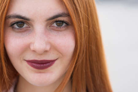 Closeup face portrait of a girl with red hair and clear eyes.の写真素材