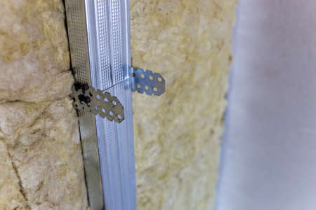 Wall of a room under renovation with mineral rock wool insulation and metal frame prepared for drywall plates.の写真素材
