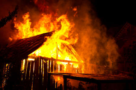 Wooden house or barn burning on fire at night.の写真素材