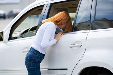 Yong pretty woman standing near a big all terrain car outdoors. Driver girl in casual clothes outside her vehicle.の写真素材