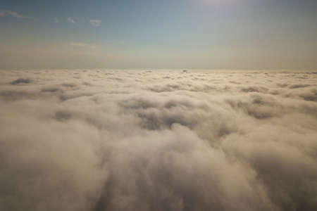 Aerial view over white clouds and clear blue sky.