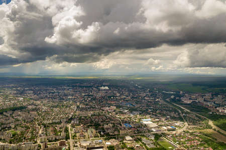 Aerial view of town or city with rows of buildings and curvy streets in summer. Urban landscape from...