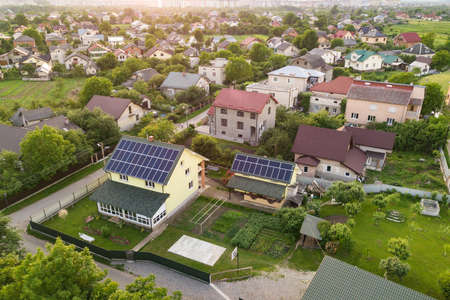 Aerial top view of new modern residential house cottage with blue shiny solar photo voltaic panels system on roof. Renewable ecological green energy production concept.の写真素材