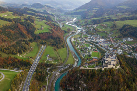 Aerial view of green meadows with villages and forest in austrian Alps mountains.