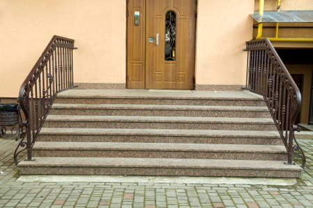 Detail of a house facade. New granite stairs with metal railings.の写真素材