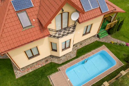 Aerial view of a new autonomous house with solar panels and water heating radiators on the roof and...