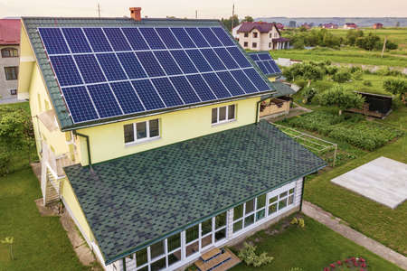 Aerial top view of new modern residential house cottage with blue shiny solar photo voltaic panels...