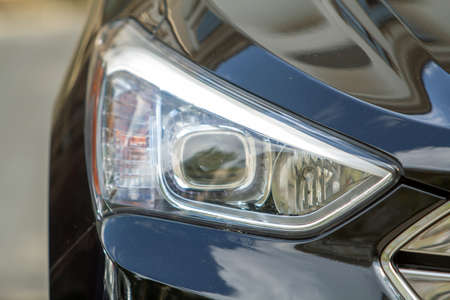 Headlamp of a car parked near curb on the side of the street on a parking lot.の写真素材