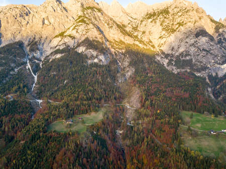 Aerial view of majestic european Alps mountains covered in evergreen pine forest in autumn.の写真素材