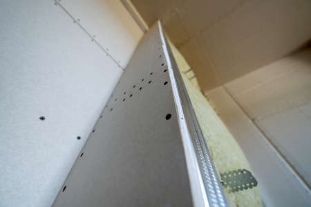 Wall of a room under renovation with mineral rock wool insulation and metal frame prepared for drywall plates.の写真素材