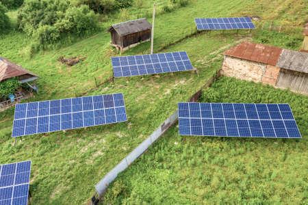 Aerial top down view of solar panels in green rural area.