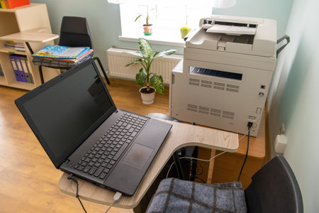 Open black laptop computer on a small chair table in office interior.の写真素材