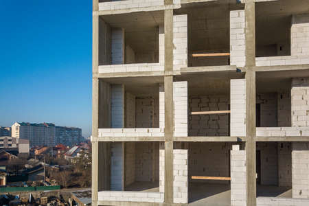 Aerial view of concrete frame of tall apartment building under construction in a city.の写真素材