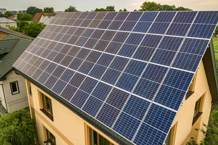 Aerial top view of new modern residential house cottage with blue shiny solar photo voltaic panels...