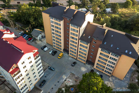 Aerial view of multistory apartment buildings in green residential area.