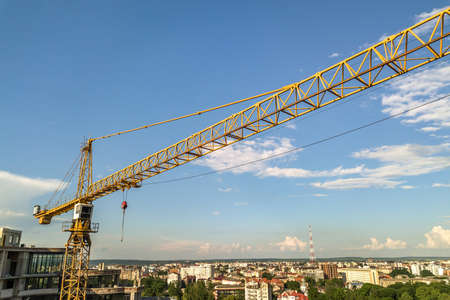Apartment or office tall building under construction. Brick walls, glass windows, scaffolding and...
