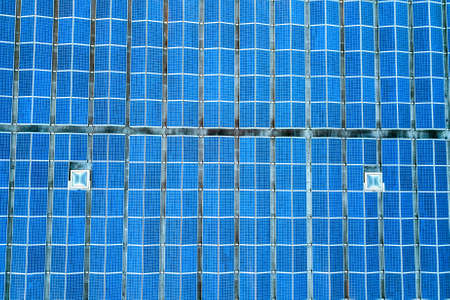 Aerial view of many photo voltaic solar panels mounted of industrial building roof.の写真素材