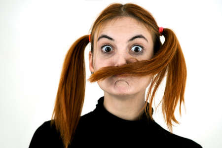 Close up portrait of pretty redhead teenage girl fooling around.