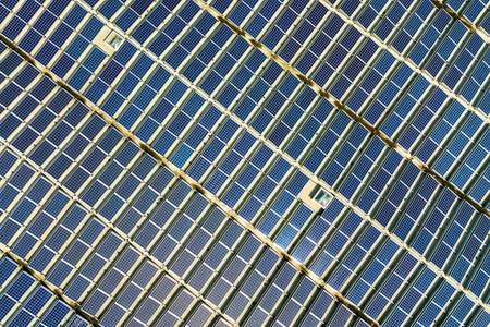 Aerial view of many photo voltaic solar panels mounted of industrial building roof.の写真素材