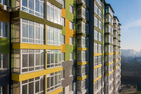 Aerial view of a tall residential apartment building with many windows and balconies.