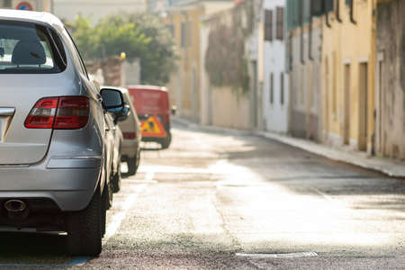 Modern cars parked on city street side in residential discrict. Shiny vehicles parked by the curb....