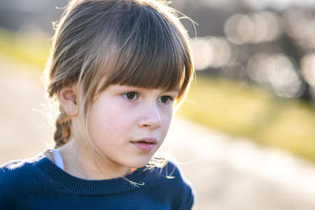 Portrait of a pretty child girl outdoors on a sunny warm autumn day.
