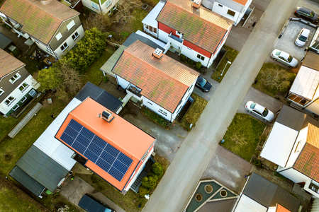 Aerial view of residential houses with red roofs and streets with parked cars in rural town area....
