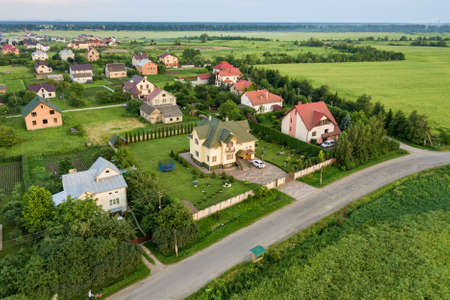 Aerial landscape of small town or village with rows of residential homes and green trees.