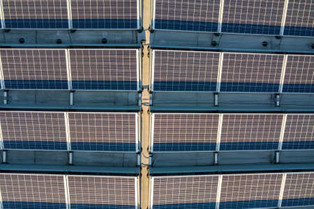 Aerial view of many photo voltaic solar panels mounted of industrial building roof.の写真素材