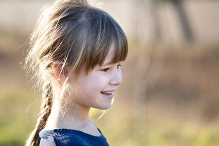 Portrait of a pretty child girl outdoors on a sunny warm autumn day.
