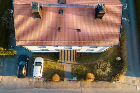 Aerial view of residential houses with red roofs and streets with parked cars in rural town area. Quiet suburbs of a modern european city.の写真素材