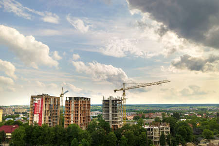 Aerial view of tower lifting crane and concrete frame of tall apartment residential buildings under...