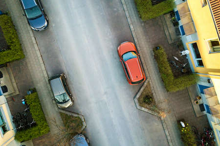 Aerial view of residential houses with red roofs and streets with parked cars in rural town area. Quiet suburbs of a modern european city.の写真素材