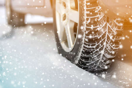 Close-up of car wheels rubber tires in deep winter snow. Transportation and safety concept.の写真素材